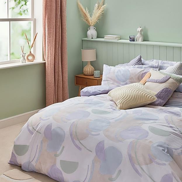 Imagen principal - Los textiles de cama (o para el sofá) son clave: los cojines cuestan entre 8 y 11 euros y la funda nórdica en tonos pastel, 18 euros.