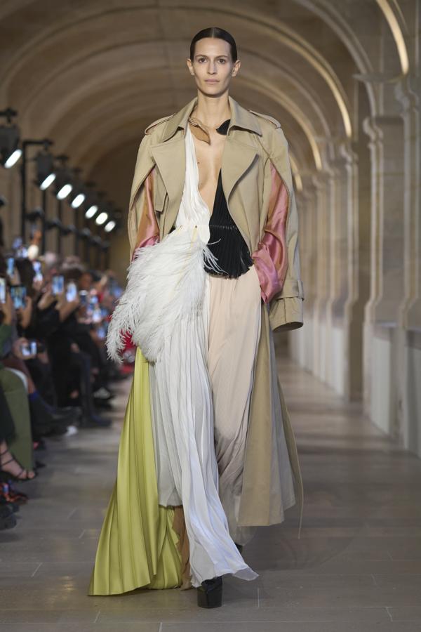 El último diseño ha sido el más aclamado. Una gabardina con múltiples cortes que crean una manga satinada que provocan un efecto fluido. Siempre rematado por plumas bicolor y tejidos etéreos. 