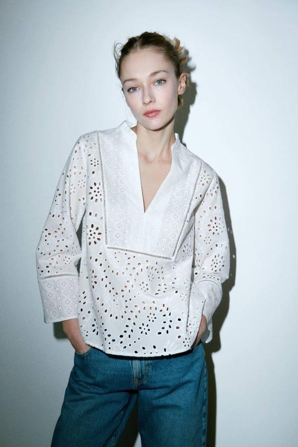 Blusa con bordados perforados, escote de pico, manga larga y entredoses, de Zara. Está disponible a 29,95 euros.