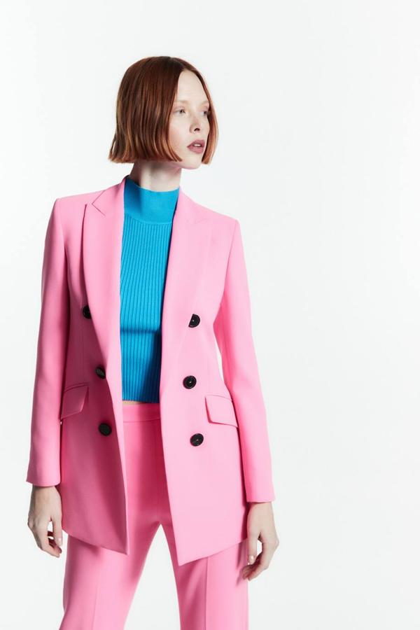 Blazer cruzada con cuello solapa de pico, hombros marcados, manga larga y cierre de doble botonadura, color rosa. Puedes encontrarla por 59,99 euros.