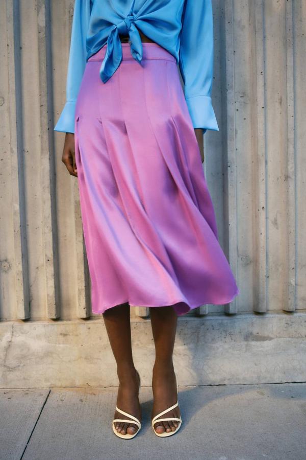 Falda midi en tejido satinado con diseño de tablas, vuelo y tiro alto, color morado, de Zara. Está disponible a 29,95 euros.