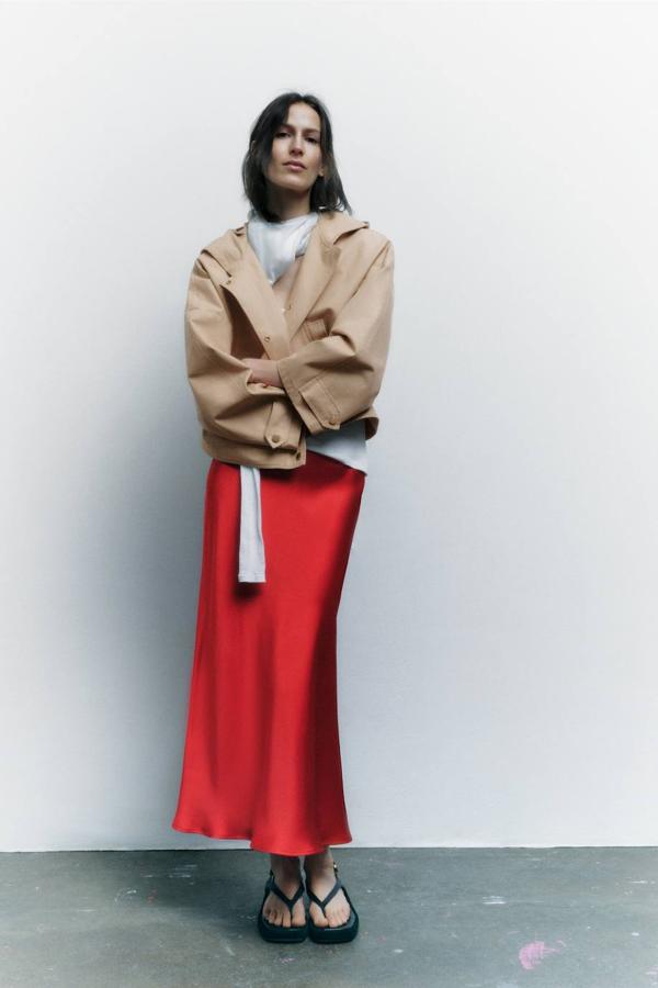 Falda midi satinada con tiro alto y bajo acabado en evasé, en rojo, de Zara. Cuesta 25,95 euros.