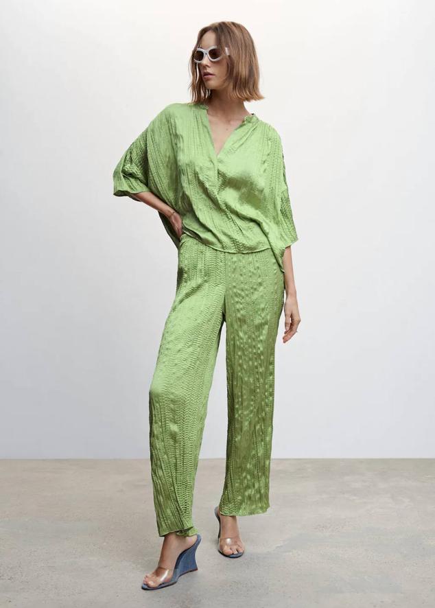 Look en tejido plisado satinado con blusa oversize y pantalón de cintura elástica, tono verde. Consíguelo a 27,99 euros y 29,99 euros.