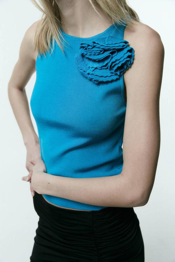 Top en tejido de punto con cuello halter y detalle de flor en relieve a juego, color turquesa, de Sfera. Su precio es de 23,99 euros.