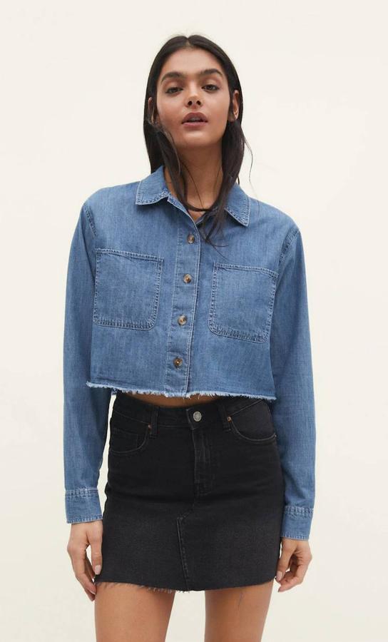 Camisa tejana con diseño cropped, bajo desflecado, bolsillos grandes, cuello solapa y manga larga, de Stradivarius. Consíguela a 22,99 euros.