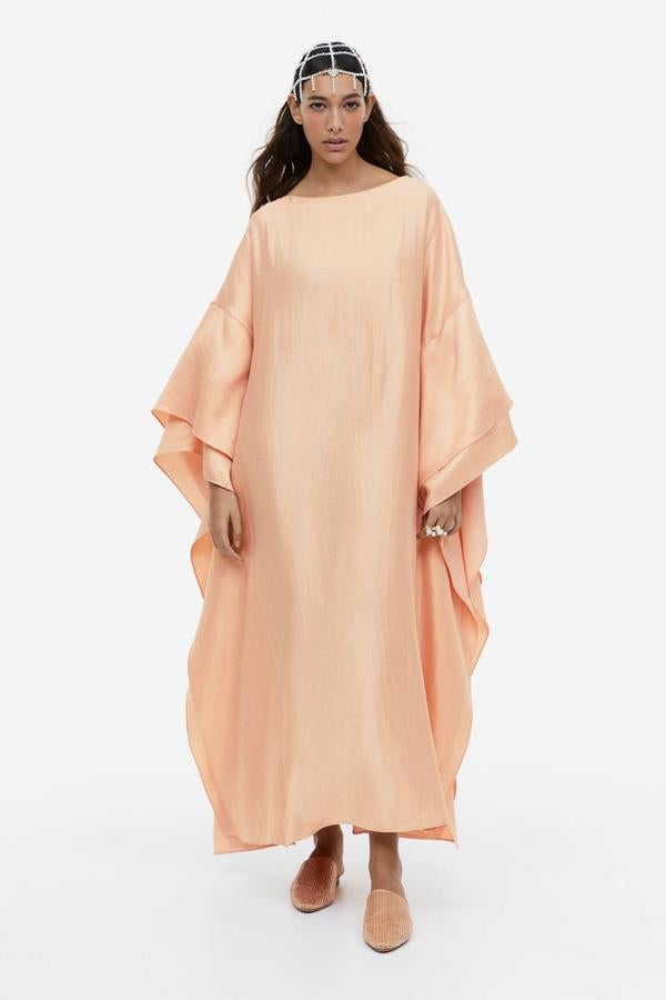 Vestido largo de corte relajado con escote barco y mangas maxi volumen con doble volante, color beige rosado. Te costará 79,99 euros.
