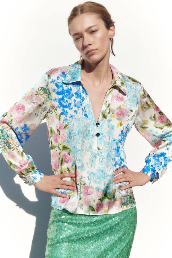 Blusa satinada con manga larga, cuello solapa, escote de pico y botones, en estampado de flores multicolor, de Zara. La comprarás por 25,95 euros.