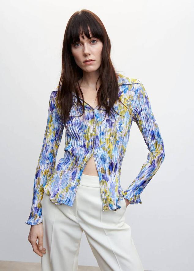 Camisa en tejido elástico fruncido con cuello solapa, manga larga, cierre de botones y estampado de flores azul, de Mango. Hazte con ella a 35,99 euros.
