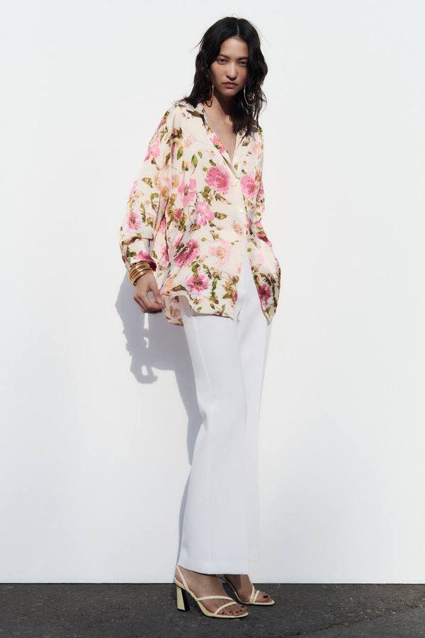 Camisa en tejido satinado con corte fluido, cuello solapa, manga larga y cierre de botones, en estampado de flores crudo y rosa, de Zara. Está disponible por 19,95 euros.