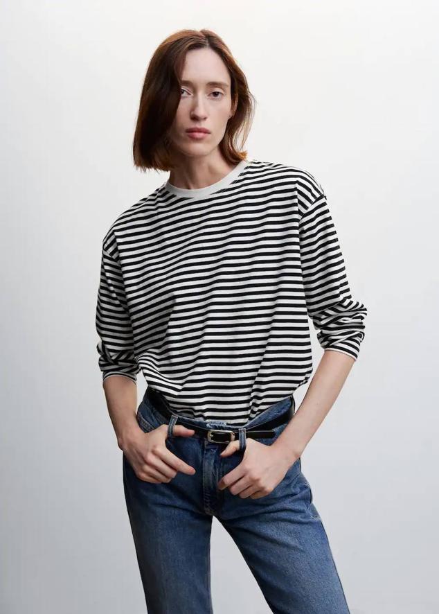 Camiseta oversize de algodón con cuello redondo, manga larga y estampado a rayas en blanco y negro, de Mango. Te costará 19,99 euros.