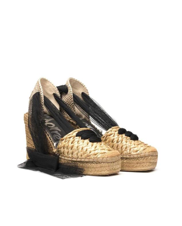 Alpargatas de cuña con tejido de radia trenzado, punta redonda y cintas en tul a contraste, tono natural y negro, de Vidorreta. Te costarán 85 euros en El Corte Inglés.