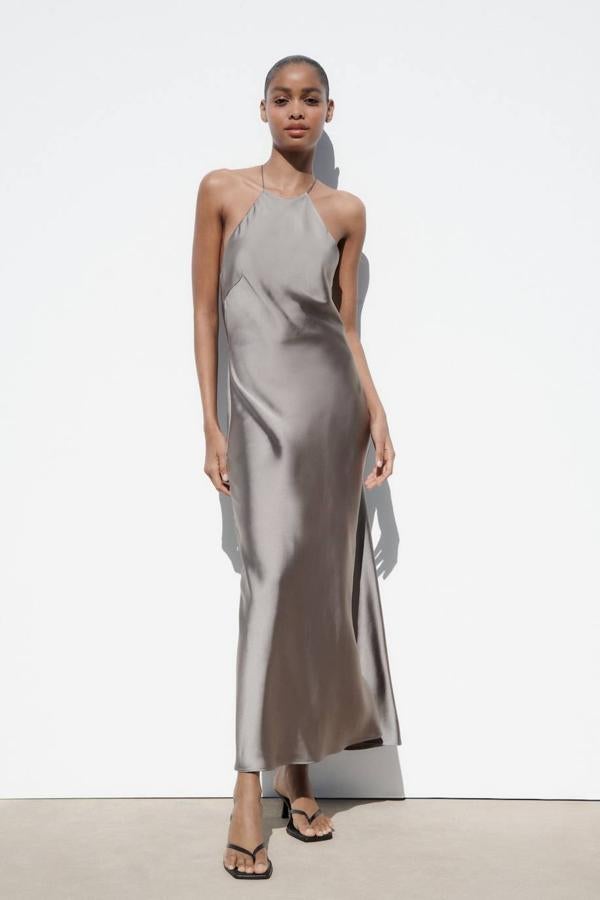 Vestido lencero satinado con cuello halter y tirantes finos cruzados, color carbón, de Zara. Está disponible a 35,95 euros.