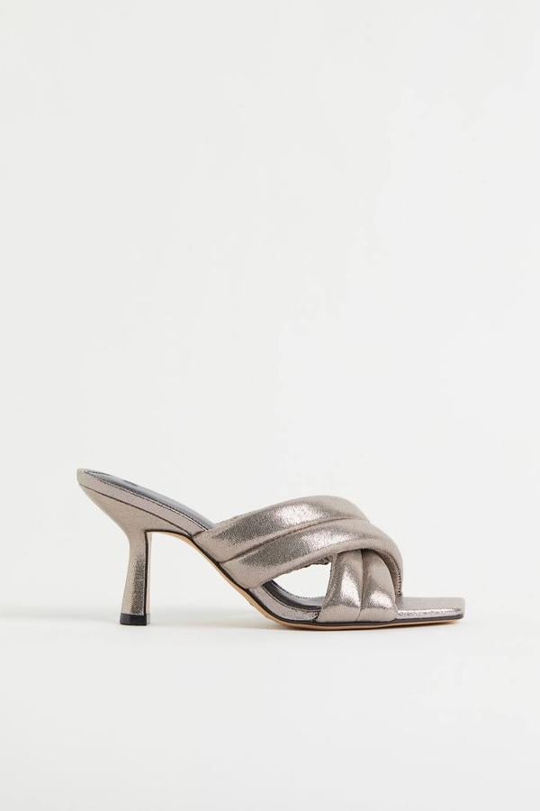 Zapatos tipo mule con tacón bajo, diseño destalonado y tiras acolchadas cruzadas con efecto metaliza, en bronce, de H&M. Puedes encontrarlos a 34,99 euros.