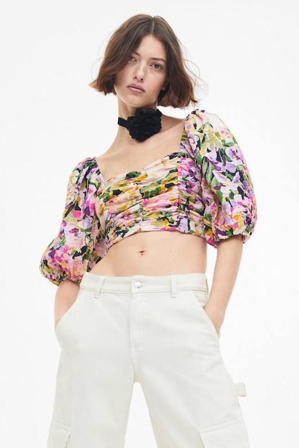 Top cropped en tejido fruncido con mangas cortas abullonadas y floral print multicolor, de H&M. Te costará 19,99 euros.