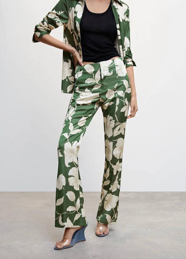 Pantalón en tejido fluido con tiro alto y perneras ajustadas y acampanadas, en maxi floral print verde y crudo. Está disponible por 39,99 euros.