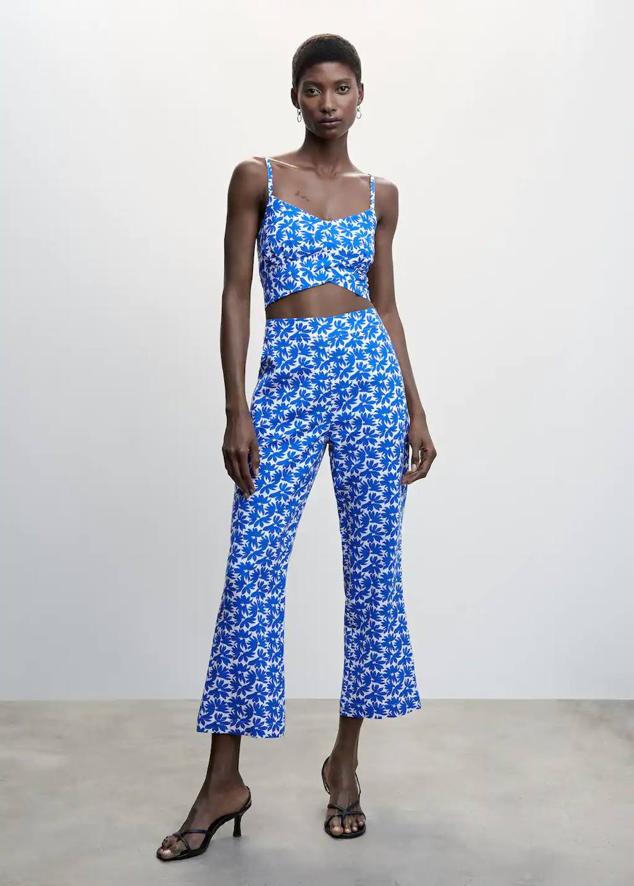 Pantalón en tejido de algodón con tiro alto y perneras flare, en floral print azul. Cómpralo por 35,99 euros.