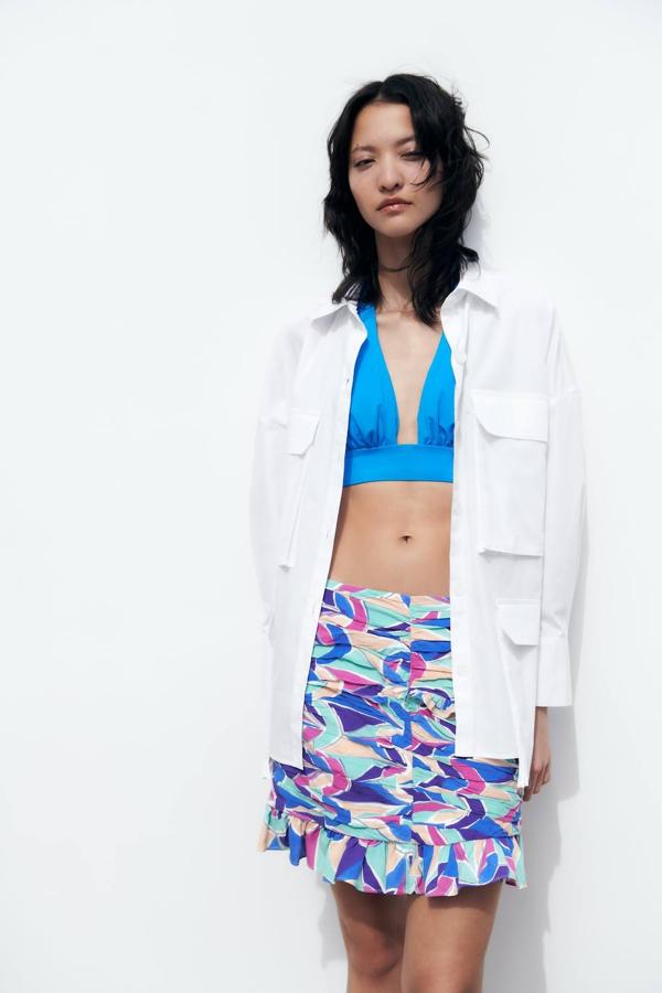 Falda corta con detalles fruncidos, volantes, tiro alto y estampado multicolor. Te costará 25,95 euros.