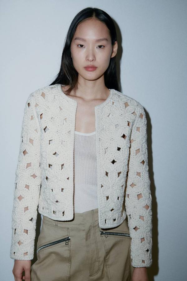 Chaqueta en tejido de punto crochet con diseño abierto, cuello redondo y manga larga, tono crudo, de Zara. Cuesta 49,95 euros.