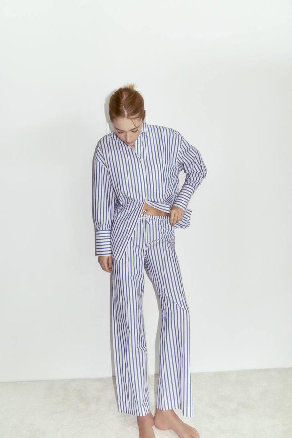 Pantalón en tejido de popelín con tiro alto y cintura elástica ajustable mediante cordón, en estampado a rayas finas verticales azul y blanco, de Zara. Cuesta 22,95 euros.