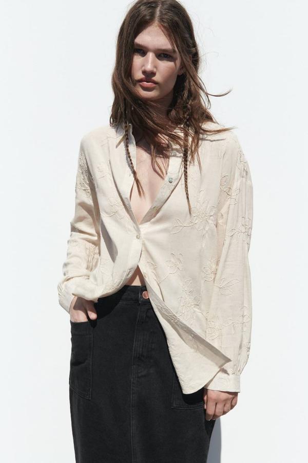 Camisa de lino oversize con cuello solapa, manga larga, cierre de botones y detalle de bordados florales, tono arena, de Zara. Puedes encontrarla a 29,95 euros.