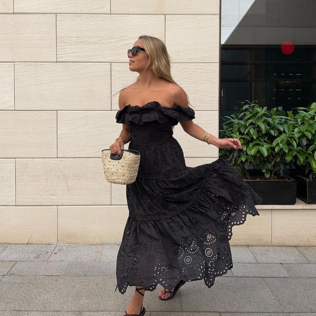 Una mujer con vestido midi en negro.