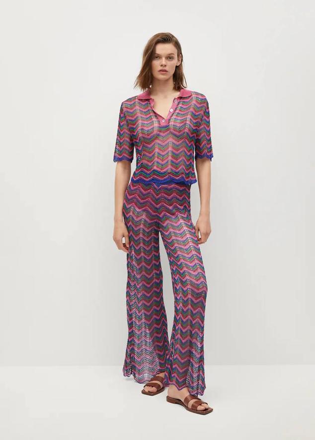 Pantalón de crochet con tiro alto, perneras acampanadas, cintura elástica y estampado en zigzag multicolor, de Mango Outlet. Su precio es de 21,99 euros.