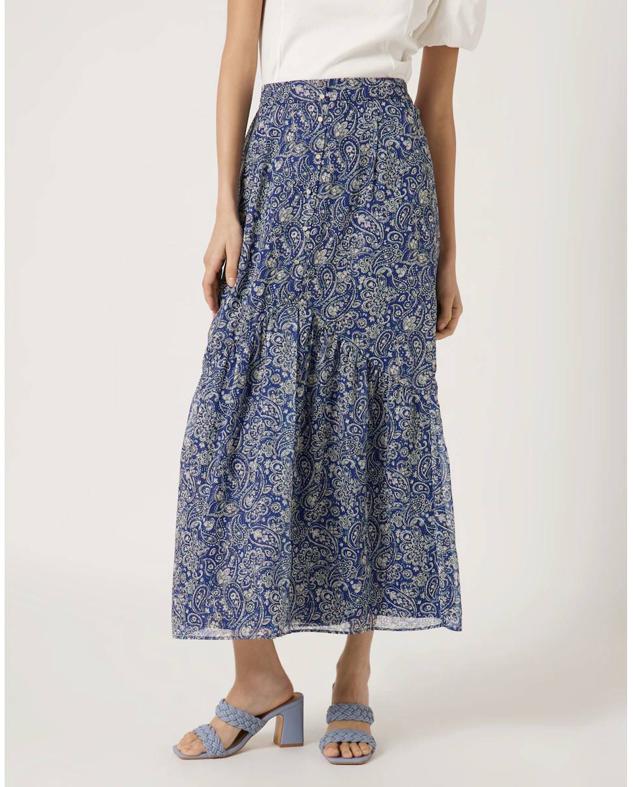 Falda larga en tejido vaporoso con tiro alto, bajo acabado en volante y estampado paisley azul, de Naf Naf. Está disponible en El Corte Inglés a 84,95 euros.