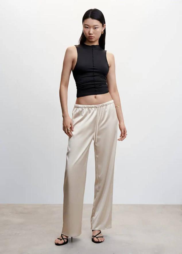 Pantalón palazzo satinado con perneras anchas y cintura elástica ajustable con cordones, en beige, de Mango. Lo comprarás por 27,99 euros.