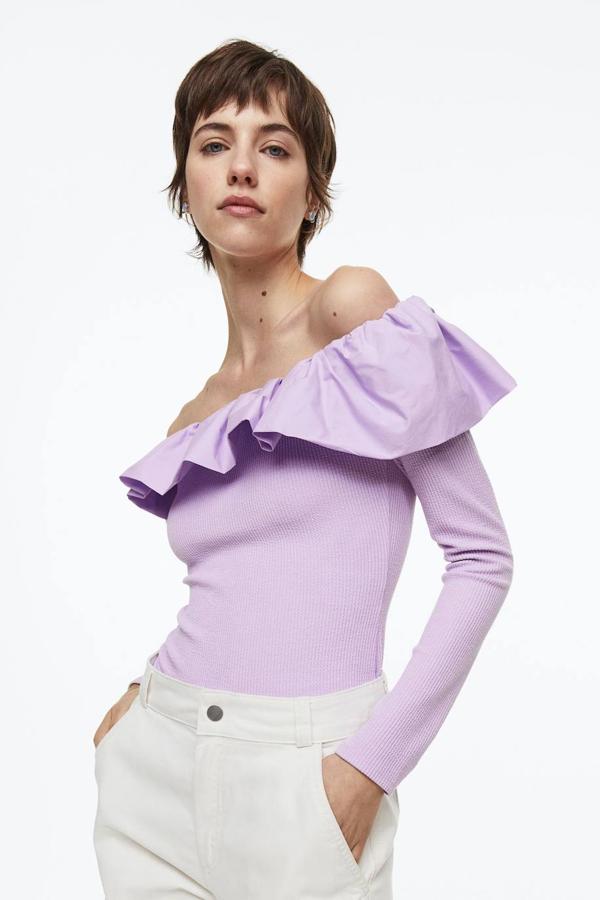 Camiseta de canalé con manga larga, hombros al descubierto y volante en el escote, en lila, de H&M. Te costará 19,99 euros.