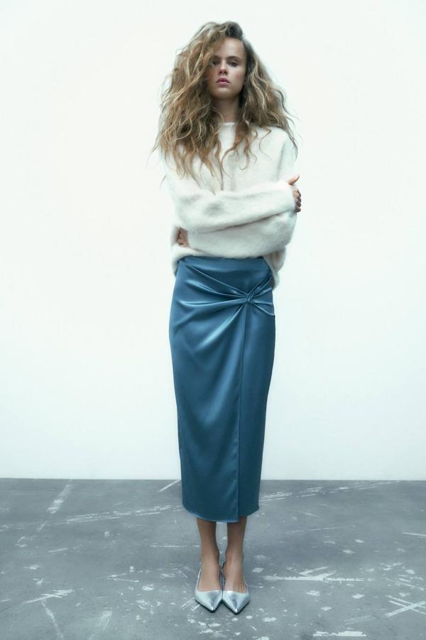 Falda midi cruzada en tejido satinado con detalle delantero de nudo, en azul, de Zara. Cuesta 25,95 euros.