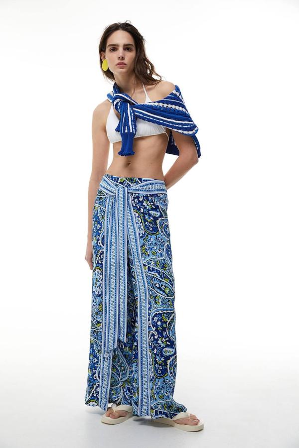 Pantalón pareo tipo palazzo con perneras extra anchas y lazada frontal, en estampado azul, de Sfera. Su precio es de 25,99 euros.