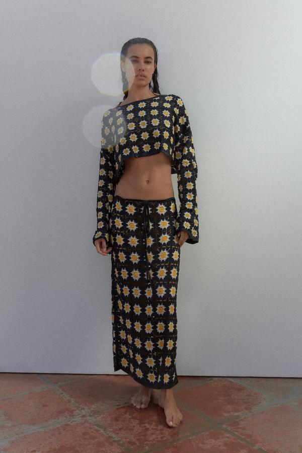 Conjunto de crochet en patrón floral con sudadera crop y falda midi, en negro, blanco y amarillo, de Zara. Está disponibles por 29,95 euros, cada pieza.