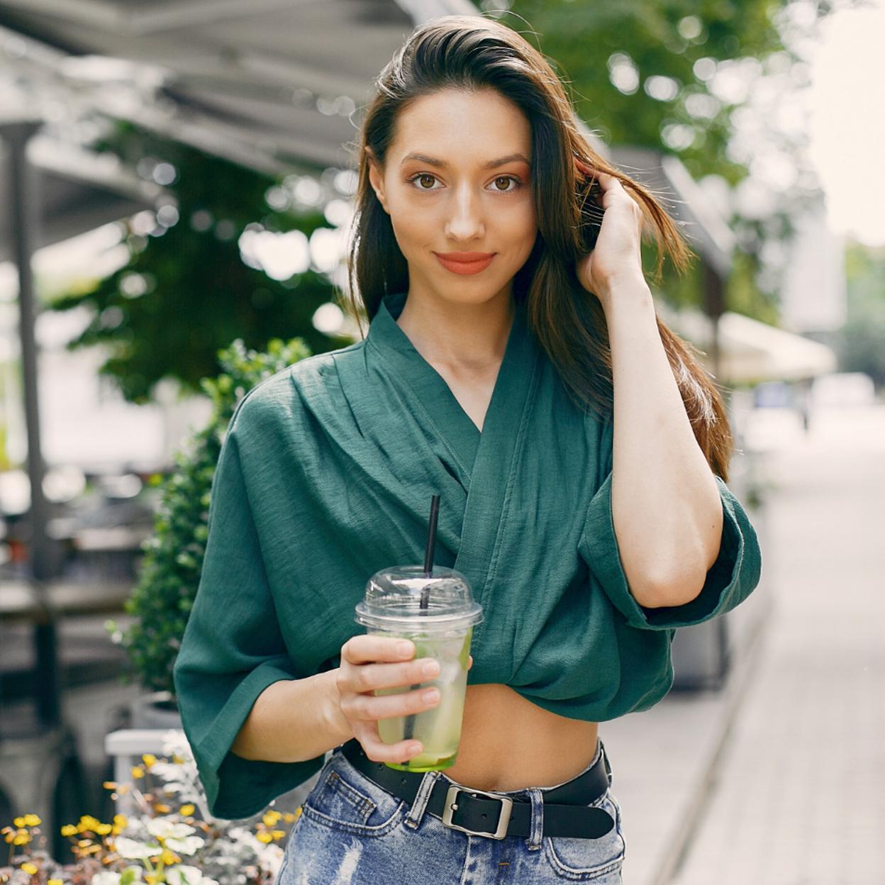 Mujer tomando un zumo verde con espirulina. 