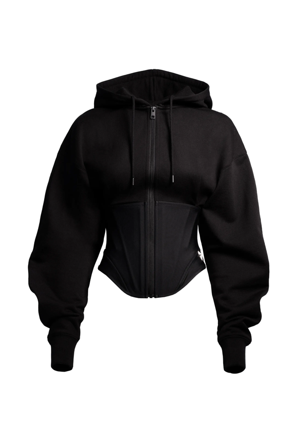 Si eres de prendas sport, atenta a esta chaqueta sudadera con cintura corsé con varillas para realzar la figura. Tiene el logotipo del diseñador en un hombro y remache de metal con la estrella de la firma en el bajo. Lleva una capucha de doble capa con cordón de ajuste, cremallera delante, hombros caídos y mangas murciélago con puños de canalé. Cuesta 99 euros.
