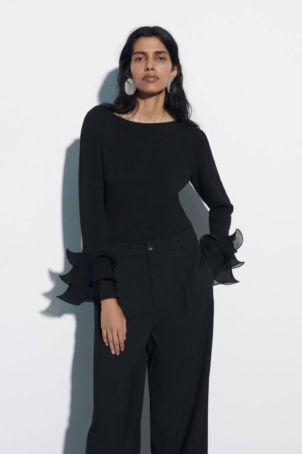 Top con cuello redondo, manga larga y puños adornados con volantes con volumen, color negro, de Zara. Te costará 29,95 euros.