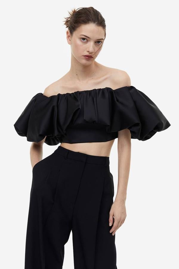 Crop top con hombros al descubierto y maxi volante con volumen, en negro, de H&M. Cuesta 49,99 euros.