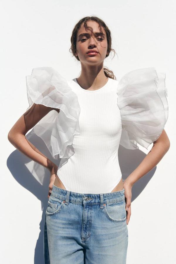 Top en tejido rib con cuello redondo, manga sisa y maxi volantes de organza, en blanco, de Zara. Puedes encontrarlo por 19,95 euros.