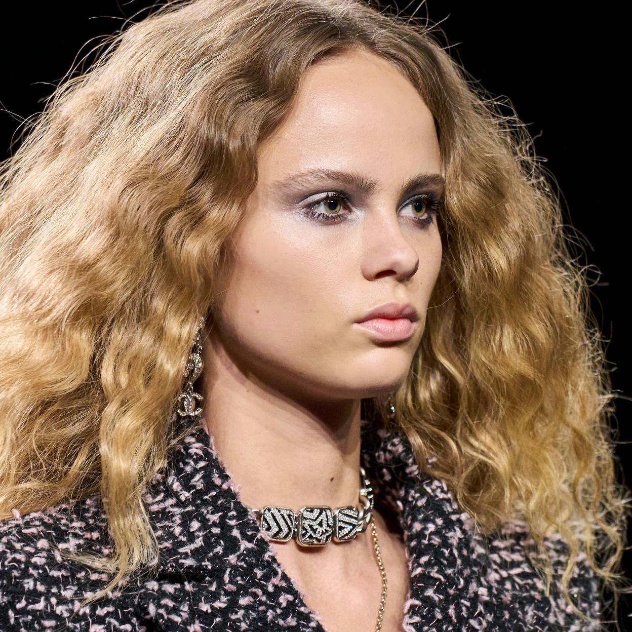 Una mujer con el pelo rubio y rizado.