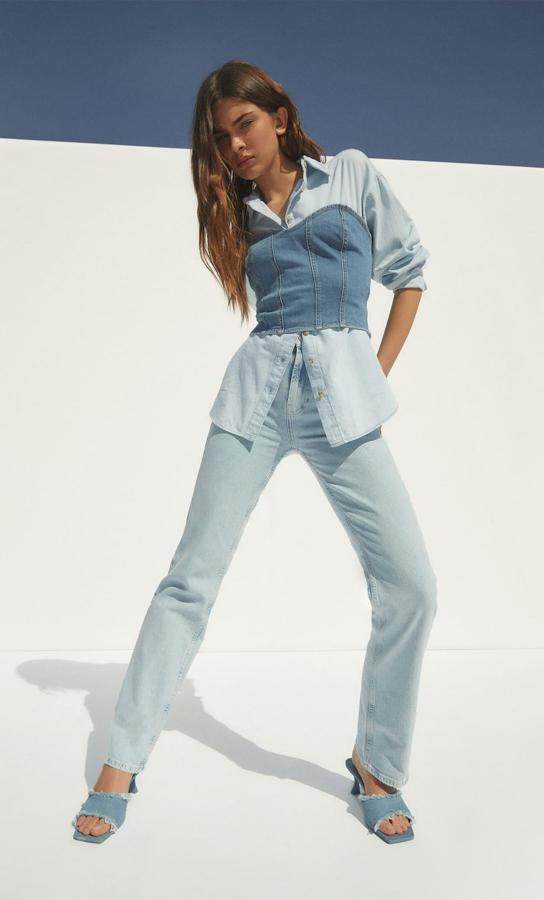 Una combinación que es toda una inspiración. Vaqueros rectos de talle alto, camisa oversize (19,99 euros), top tipo corpiño (19,99 euros) y sandalias de tacón tipo mule (35,99 euros).