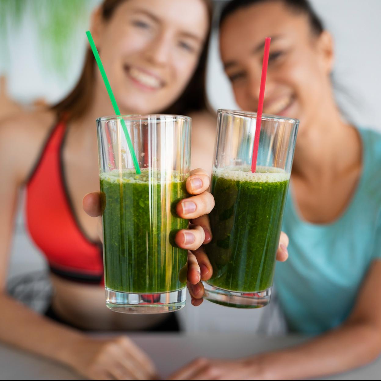 Dos mujeres tomando zumos verdes. 