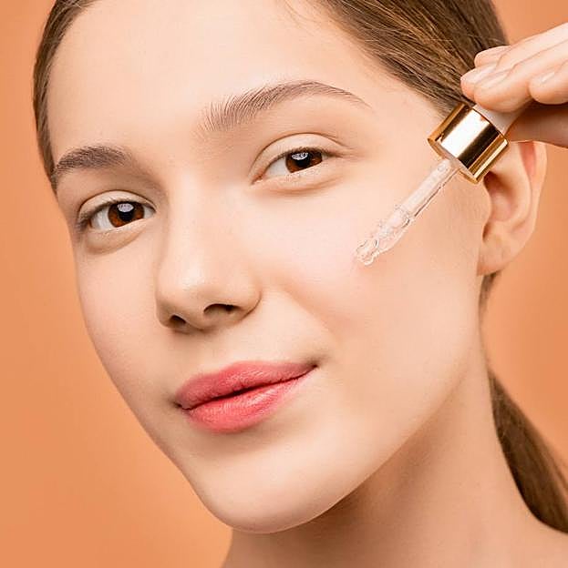 Mujer aplicando aceite de ricino en la piel