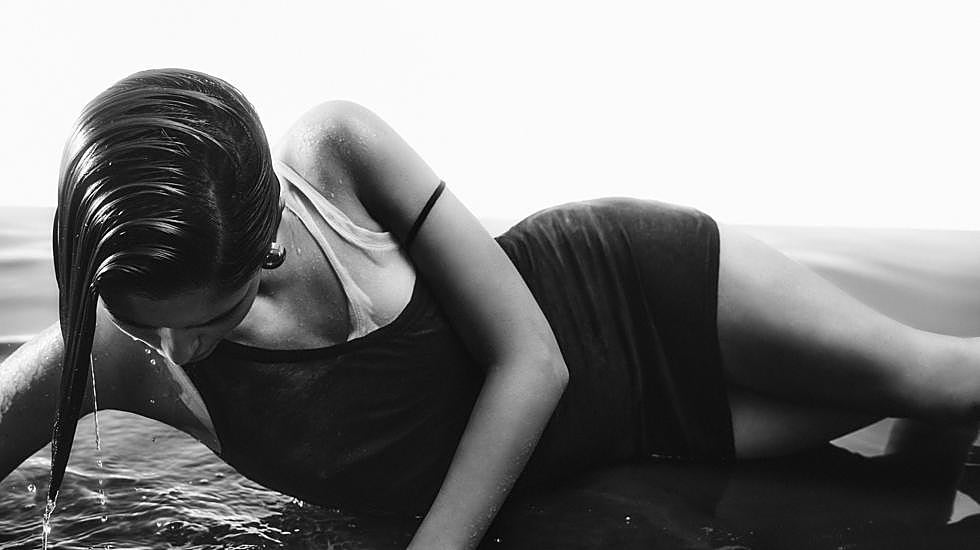 La modelo posa con varias camisetas que hacen efecto de vestido.