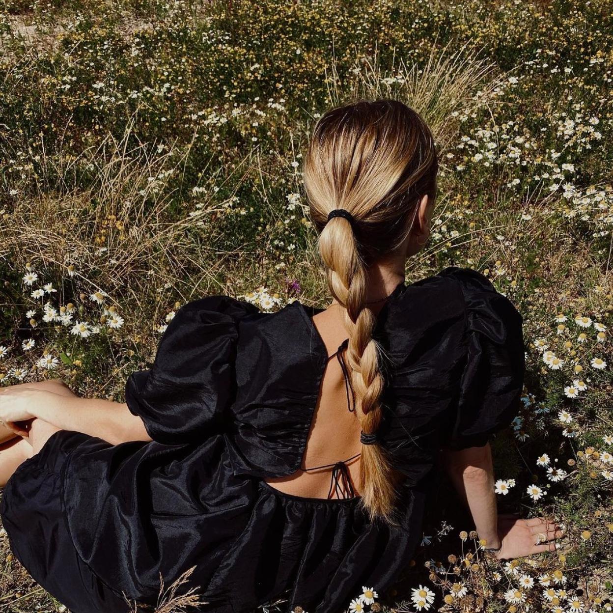 Una influencer con el cabello cuidado y un recogido con trenza.