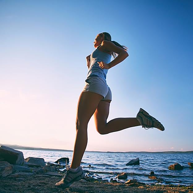 Mujer practicando running en la playa. 