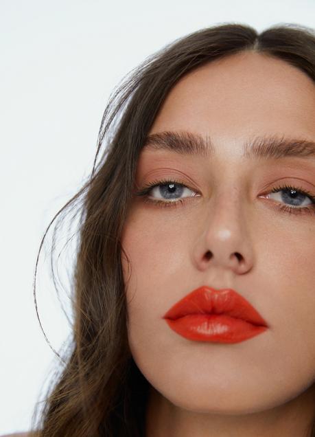 Imagen - La modelo lleva el labial Good Girl Maxi Glaze en tono 310 Carolina, de Herrera Beauty.