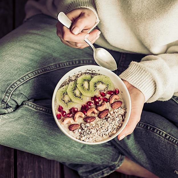 Mujer tomando un desayuno saludable. 