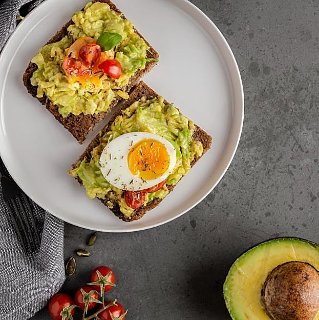 Desayuno salado saludable a base de tostadas de aguacate y huevo.