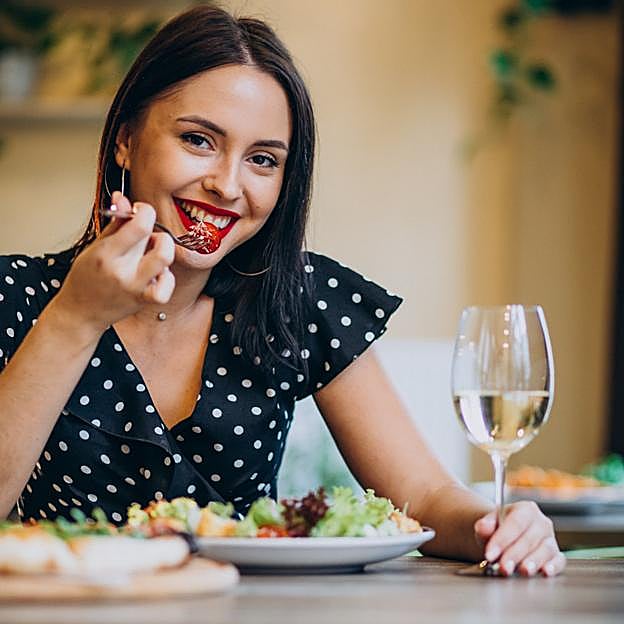 Mujer cenando una ensalada. 