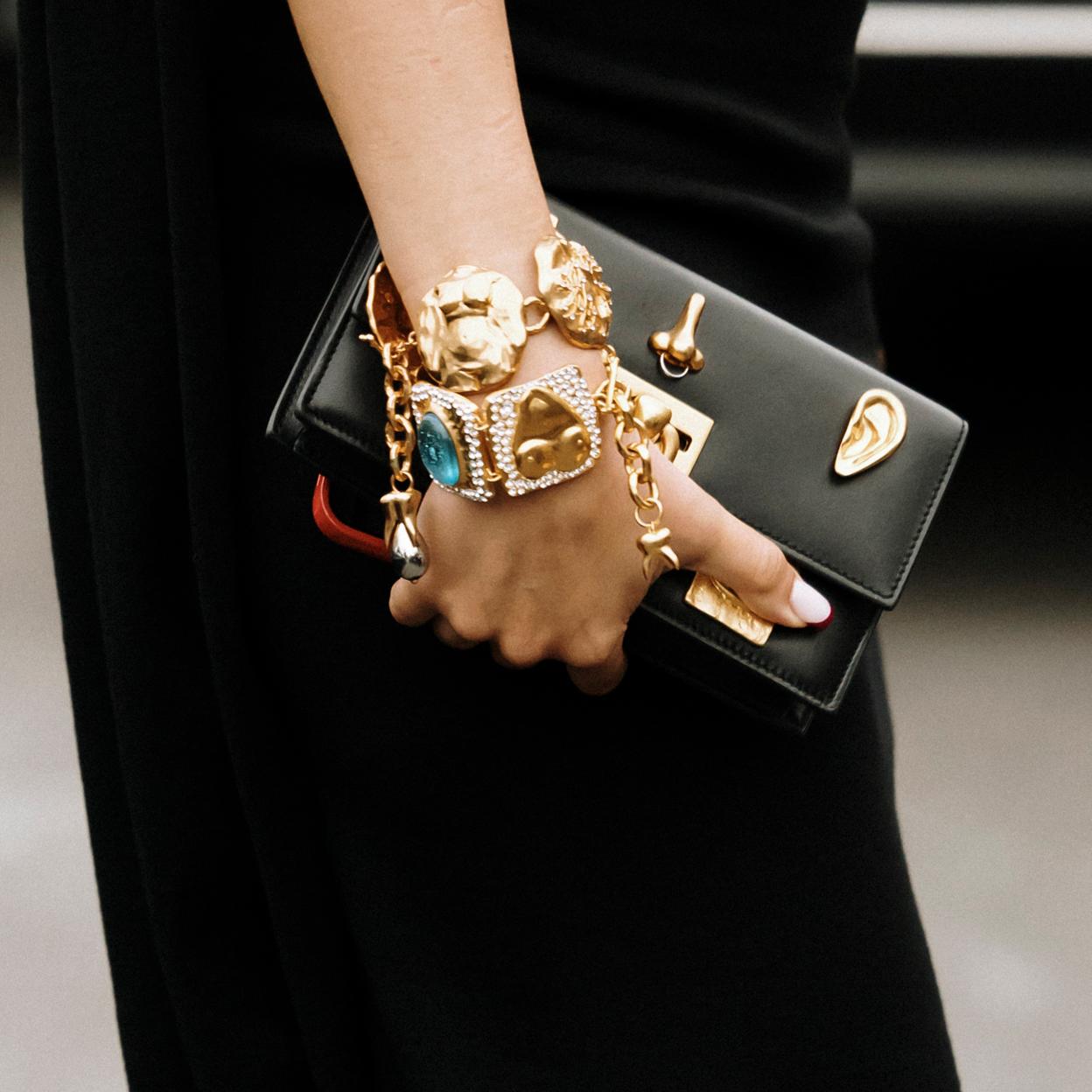 Una mujer con pulseras en dorado.