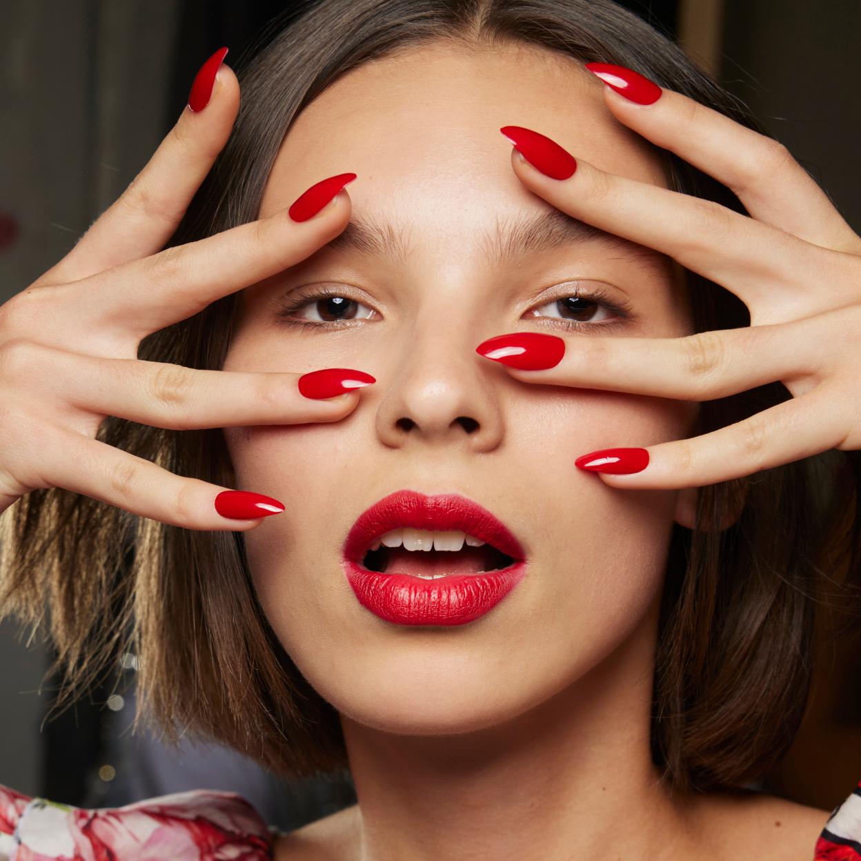 Una modelo con las uñas pintadas de rojo.